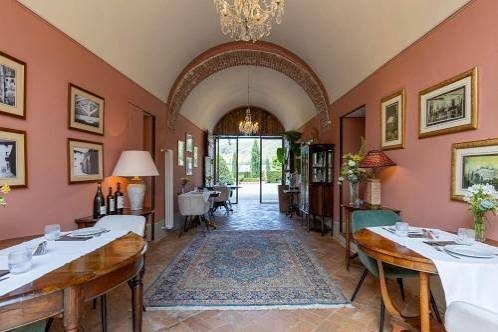 The vaulted dining room, tables laid, doors open onto the garden